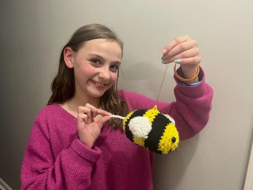 Seren holding a crocheted bee